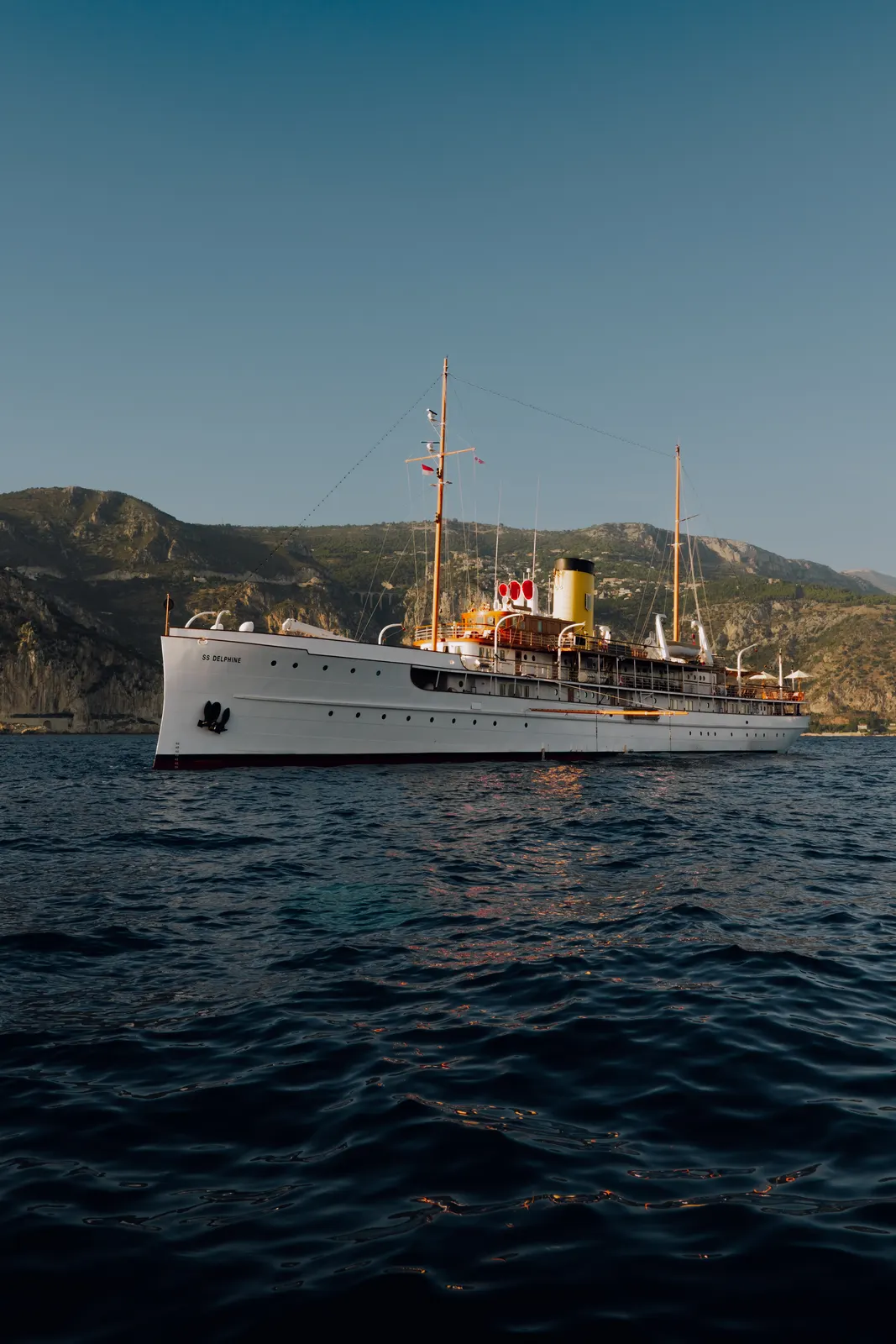 SS Delphine lying broadside beneath tall coastal cliffs.
