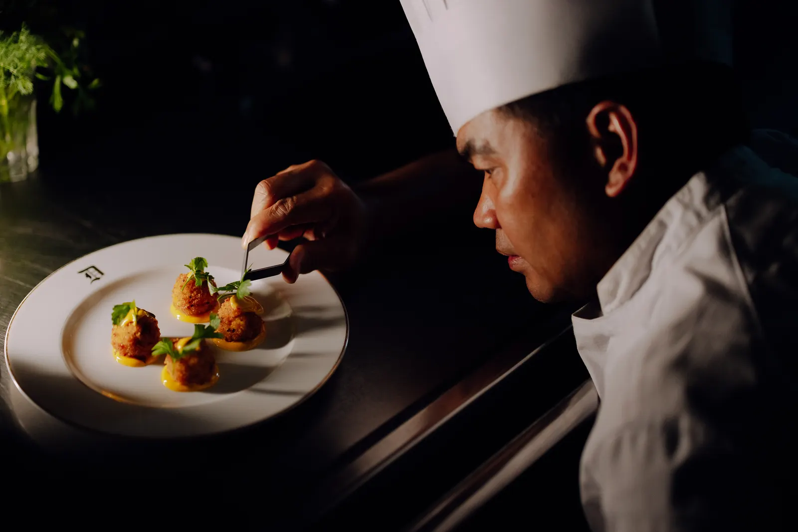 The chef finishing a plate by hand.