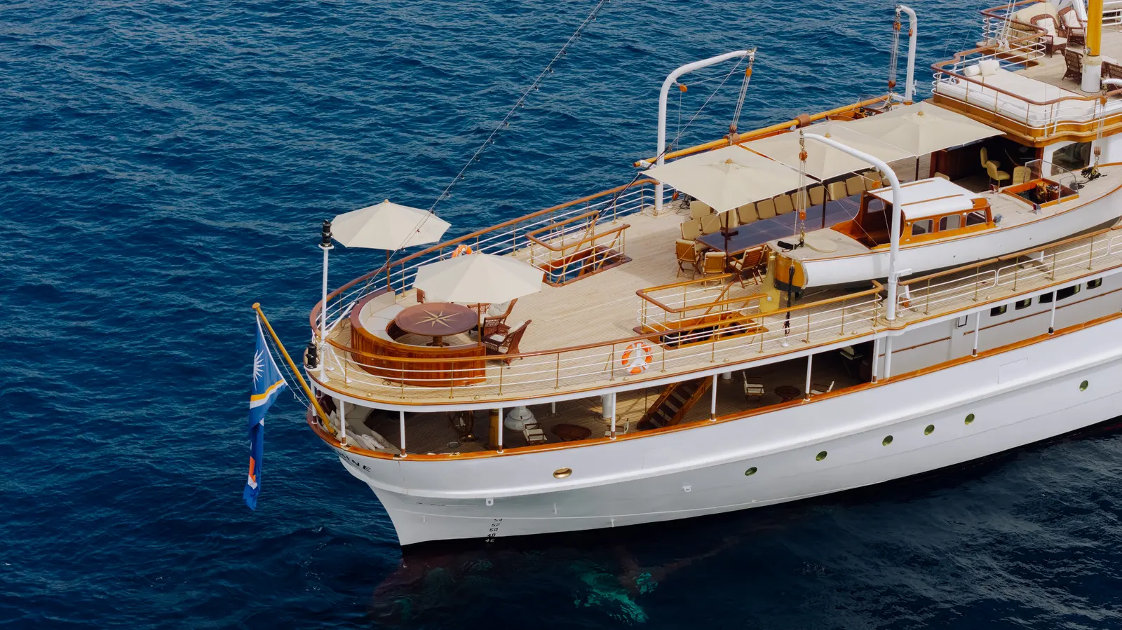 The teak decks, wheelhouse and funnel of SS Delphine seen from above her starboard side.