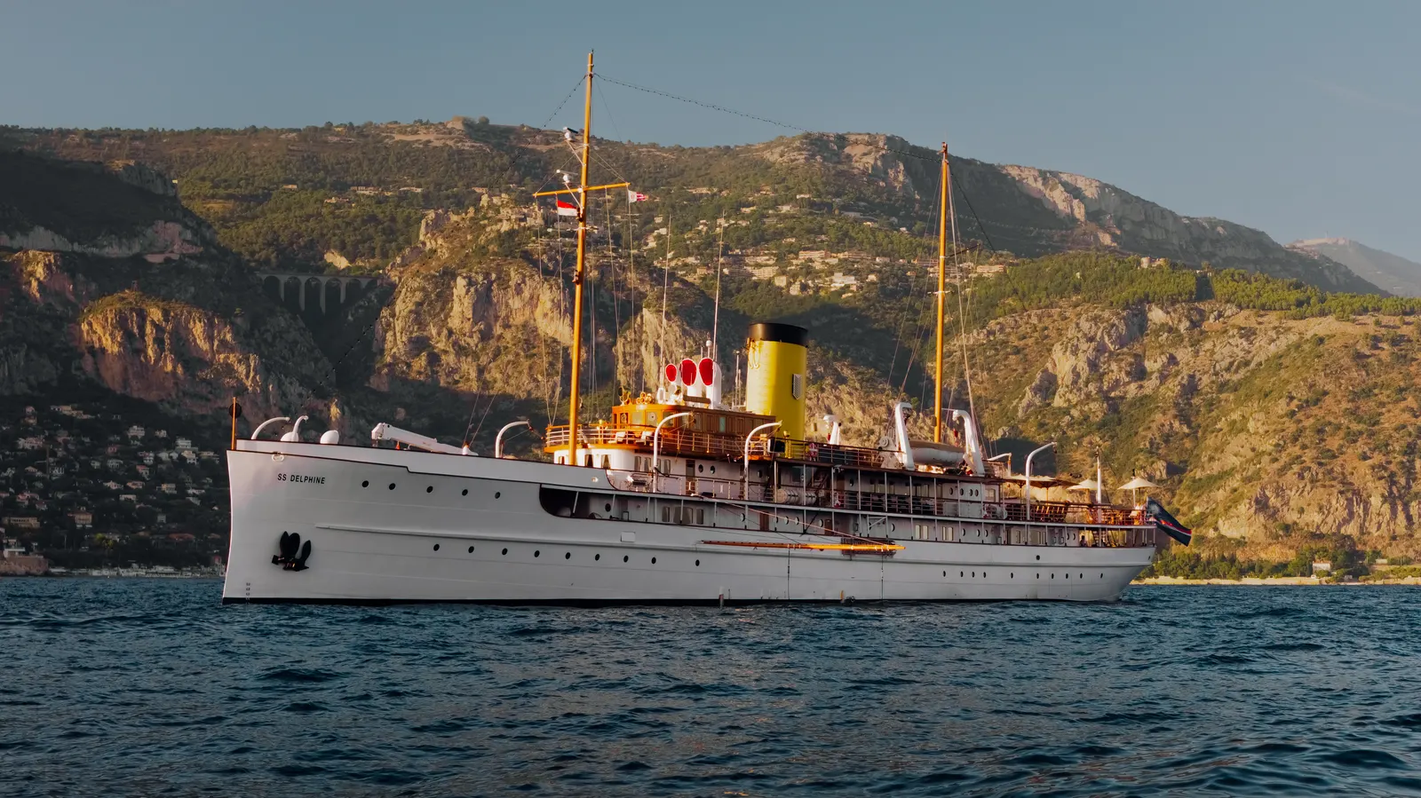 SS Delphine at rest in the last of the evening light, the coast rising behind her.