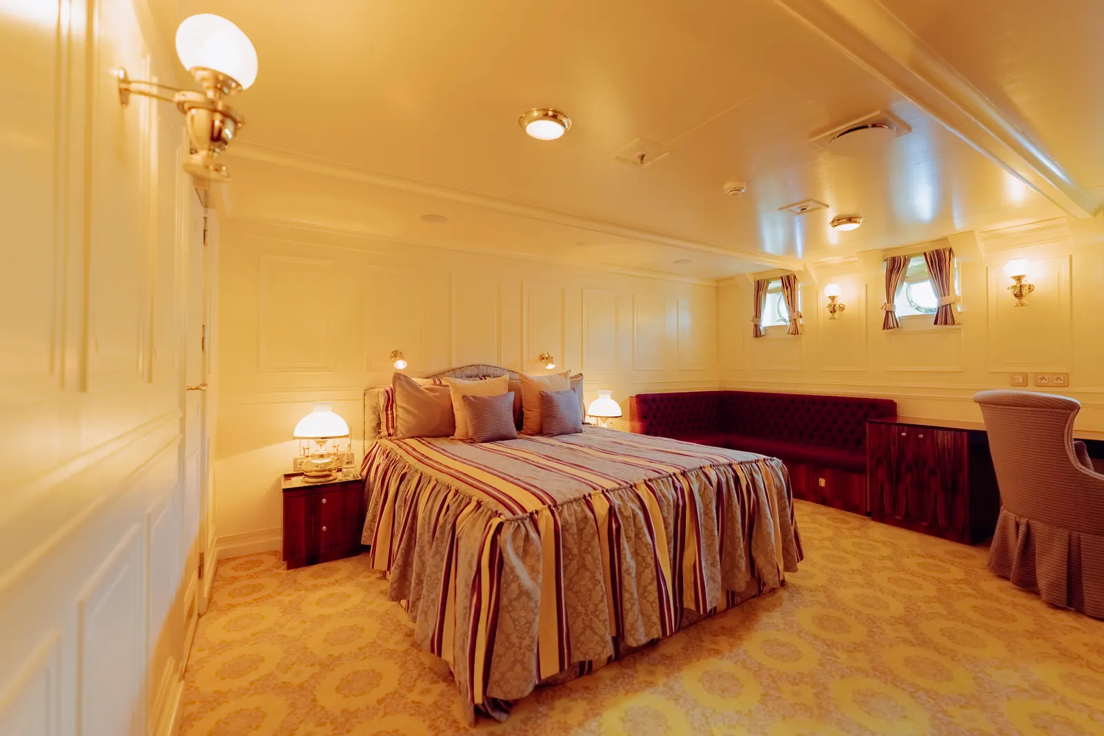 A pale double cabin with wall sconces either side of the bed.