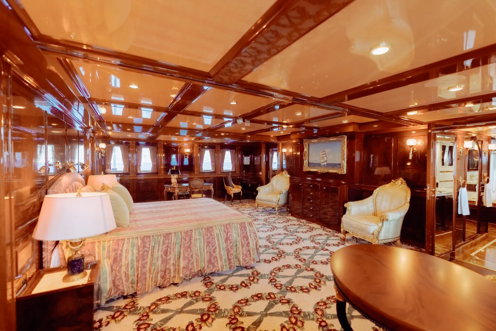 The same suite from its other end, the bed beside a round table and a reading lamp.