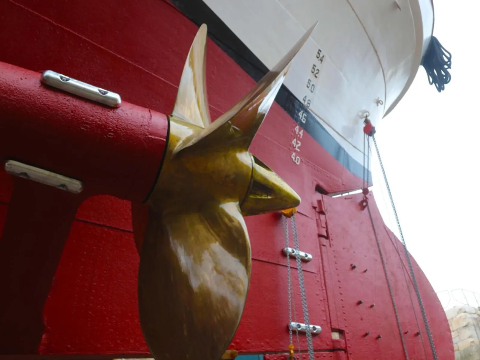 A bronze propeller and the rudder against the red antifouling.