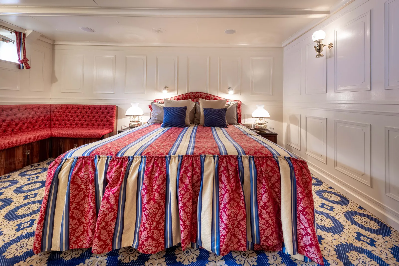 A cabin with striped textiles and a blue patterned carpet.