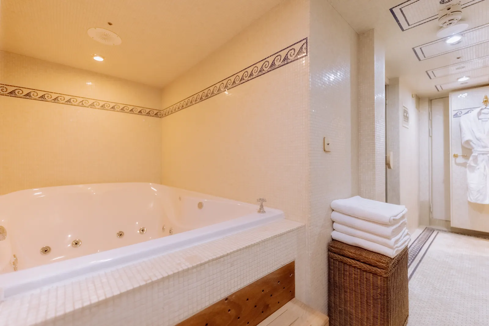 The indoor whirlpool bath, towels stacked alongside.