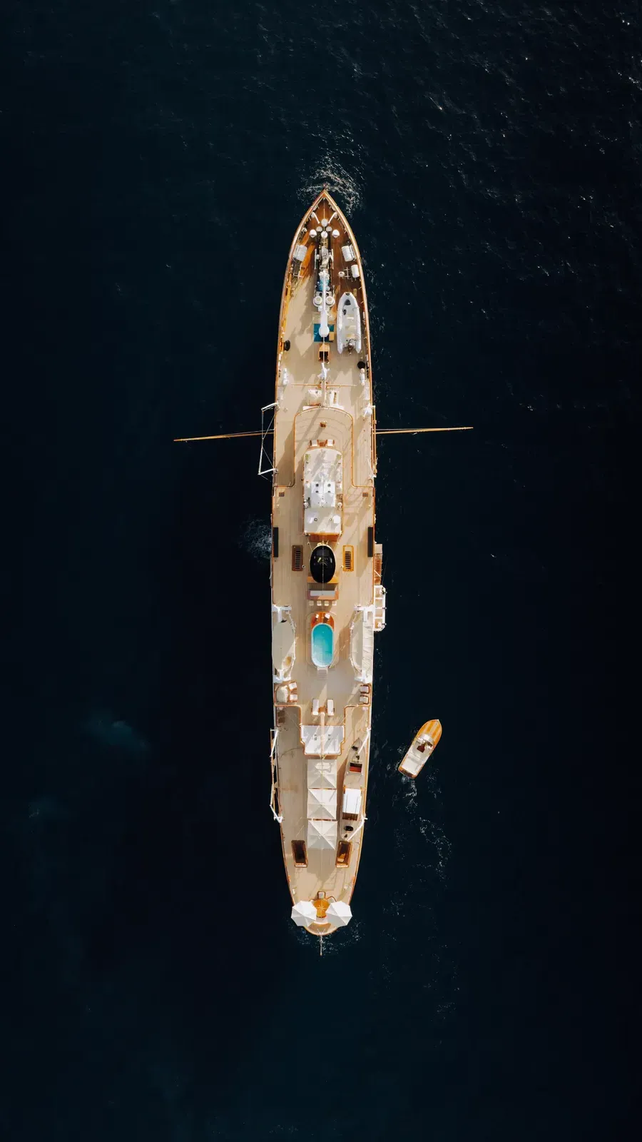 SS Delphine seen from directly above on a dark blue sea, her full length from bow to stern with her tender alongside.